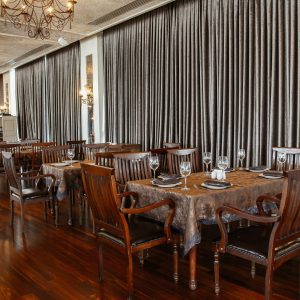 wide restaurant hall with wooden table and chairs for 6 persons